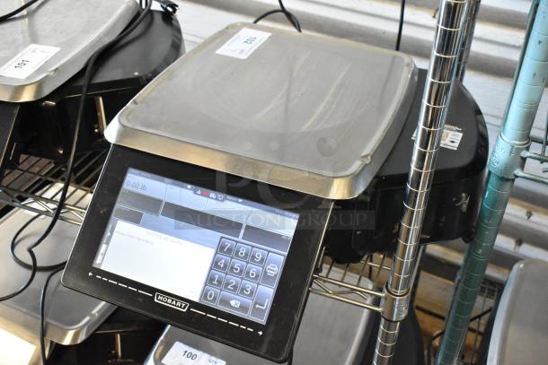 Hobart digital retail scale with touchscreen display, silver weighing platform, visible tags, excellent condition.