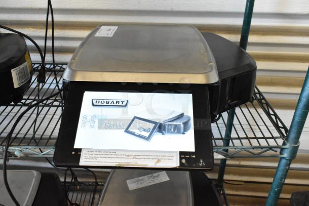 Hobart HT Series commercial scale, stainless steel, touchscreen display, used condition, includes user instructions and shelf life guide.