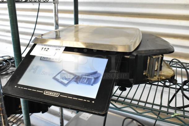Hobart HT Series scale with touchscreen interface, model number 112. Features stainless steel weighing plate.