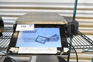 Hobart commercial scale, black, digital display, model HT Series, with tag "113" from PCI Auctions. Good condition.