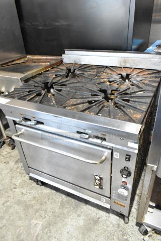Montague V136-5A Vectaire Stainless Steel Commercial Natural Gas Powered 4 Burner Range w/ Convection Oven on Commercial Casters.