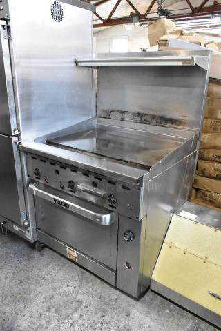 Vulcan 36S-36GTN Stainless Steel Commercial Natural Gas Powered Flat Top Griddle w/ Oven, Over Shelf and Back Splash on Commercial Casters.