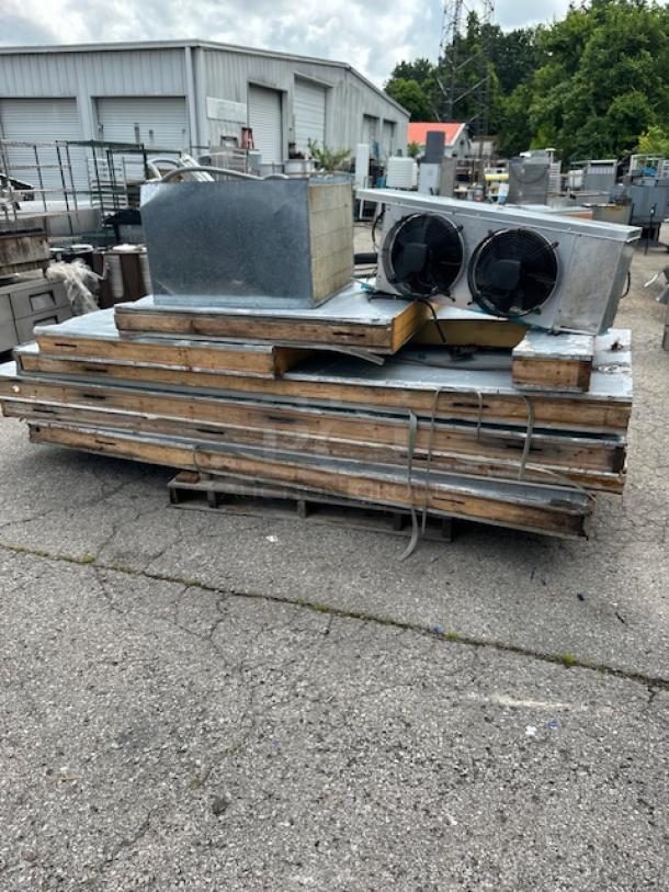 Stack of industrial HVAC equipment parts, including ducts and vents, on a pallet. Used condition with visible wear.