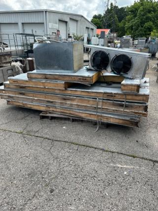 Stack of industrial HVAC equipment parts, including ducts and vents, on a pallet. Used condition with visible wear.