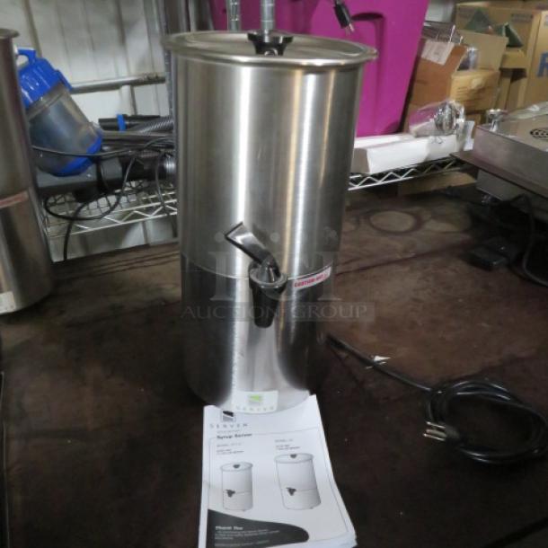 Stainless steel beverage dispenser with spigot, plug, and instruction manual, in excellent condition.