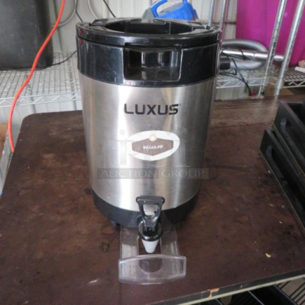 Luxus coffee dispenser, stainless steel, black trim, "Regular" label, spigot, used condition, for commercial use.