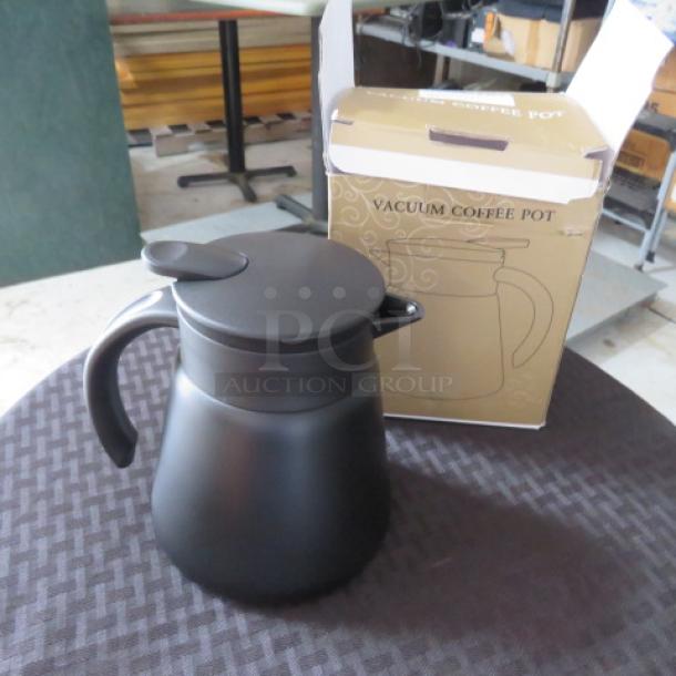 Black vacuum coffee pot with a spout and handle, shown with original box. New condition. Box labeled "VACUUM COFFEE POT."