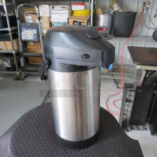 Stainless steel airpot with black lid and handle, used condition, ideal for serving hot beverages.