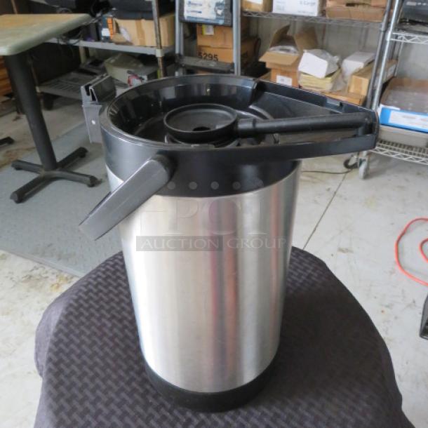 Stainless steel airpot coffee dispenser with black handle, in used condition. Ideal for catering or large gatherings.