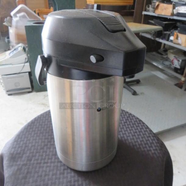 Bunn stainless steel airpot coffee dispenser with black plastic lid, used; slight surface wear; logo visible on side.