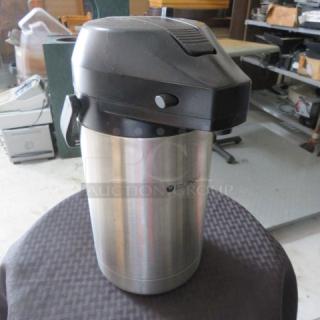 Bunn stainless steel airpot coffee dispenser with black plastic lid, used; slight surface wear; logo visible on side.