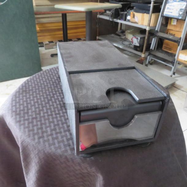 Black plastic storage box with pull-out drawer, transparent front panel, used condition. Ideal for organizing small items.