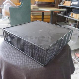 Black metal wire basket with solid base, square shape, used condition. Suitable for storage or decorative purposes.
