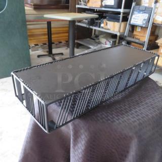 Black metal industrial-style shelf, rectangular form with wireframe sides. Good condition, suited for storage or display.