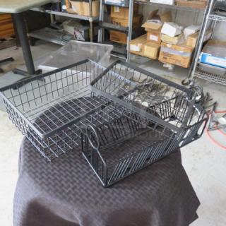Set of three black metal storage baskets in varying sizes, used, with minimal wear. Ideal for organizing spaces.
