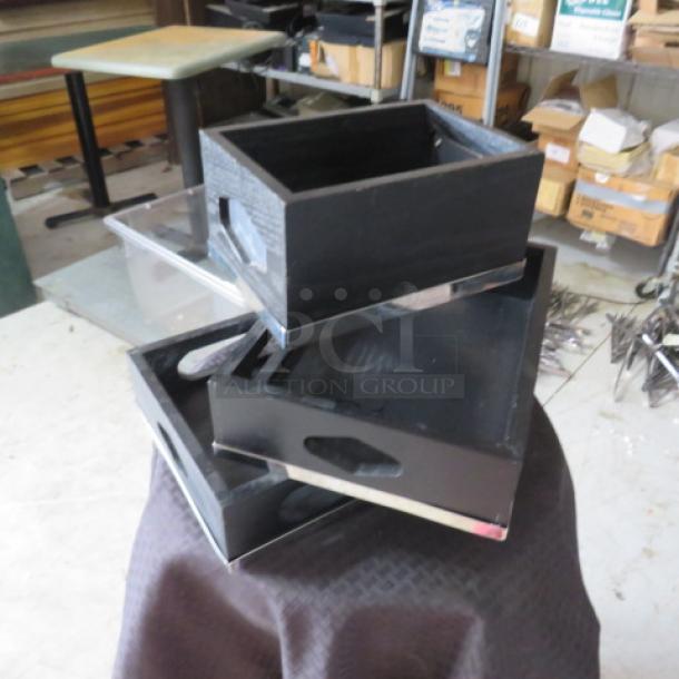Three black wooden storage boxes with cut-out handles, displayed on a table. In good condition, no visible markings.
