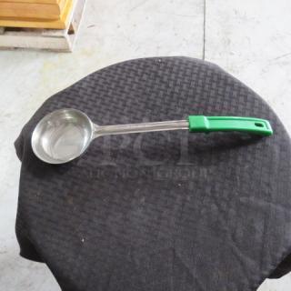Stainless steel ladle with green handle, embossed with "Choice 2oz", on round black textured cloth. Excellent condition.