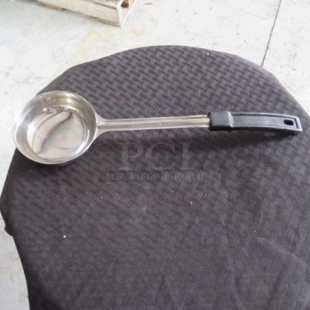 Stainless steel ladle with black grip handle, in good condition. Smooth finish, ideal for kitchen use.