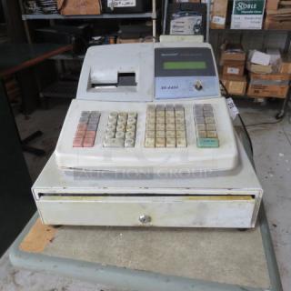 Vintage Sharp XE-A404 cash register, visible wear, numeric keypad, display screen, attached cash drawer, in used condition.