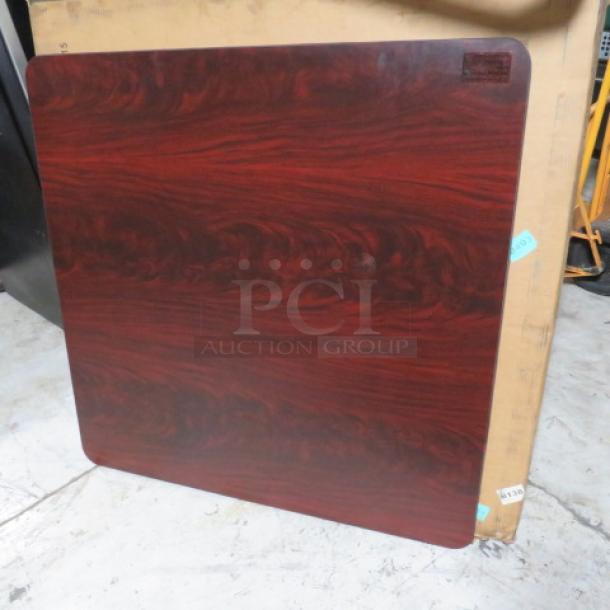 Woodgrain square tabletop, rich reddish-brown finish, polished surface. Minimal wear. Label top right indicates manufacturer.