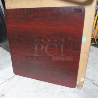 Woodgrain square tabletop, rich reddish-brown finish, polished surface. Minimal wear. Label top right indicates manufacturer.