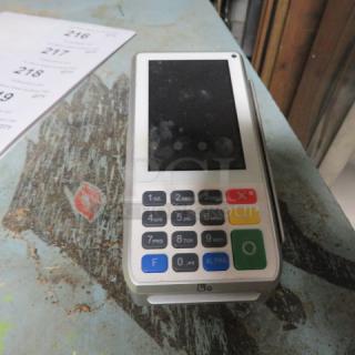 Payment terminal with keypad and display screen, featuring numeric and function buttons, appears used with some wear.