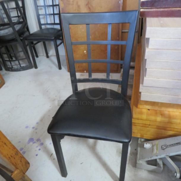 Black metal chair with padded seat, lattice back design, in fair condition. Suitable for dining or office use.