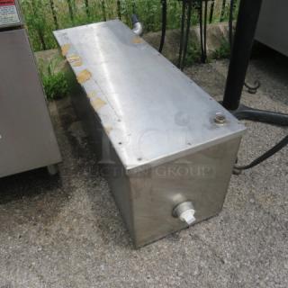 Stainless steel rectangular tank with a spout and valve, showing signs of wear and rust along the edges.