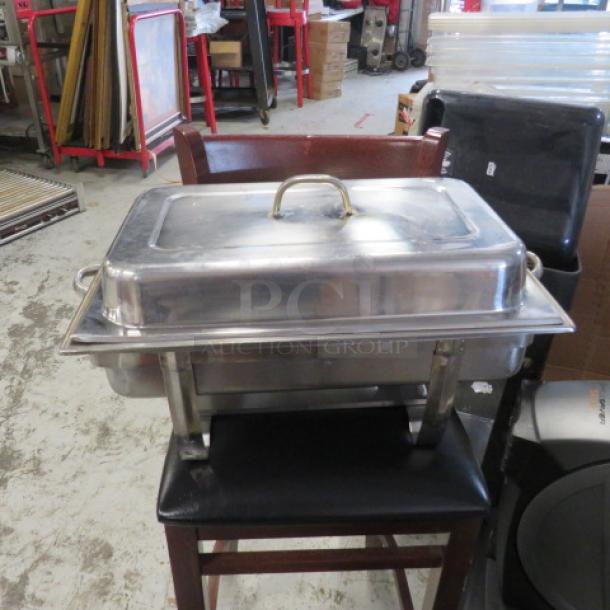 Stainless steel chafing dish with lid and handles, used condition, suitable for catering or events.