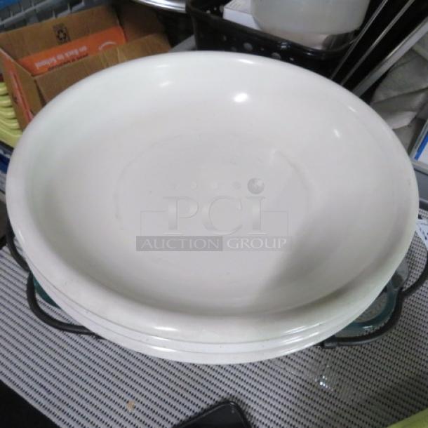 White ceramic serving bowl; large, smooth finish; minimal signs of wear. Set on a striped surface.