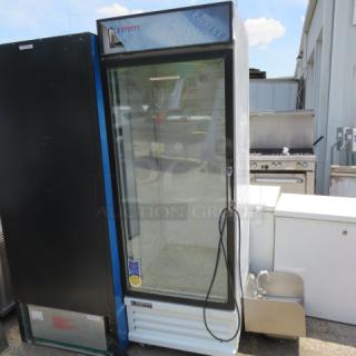 Glass door commercial refrigerator. Everest brand, model R1. Visible wear, stickers displaying branding and model. Single door unit.