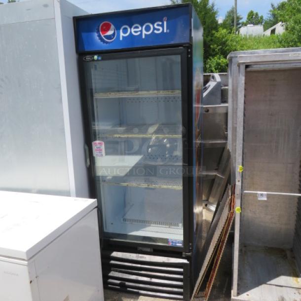 Commercial Pepsi display refrigerator, glass door, multiple shelves, exterior wear visible, branding intact, model label present.