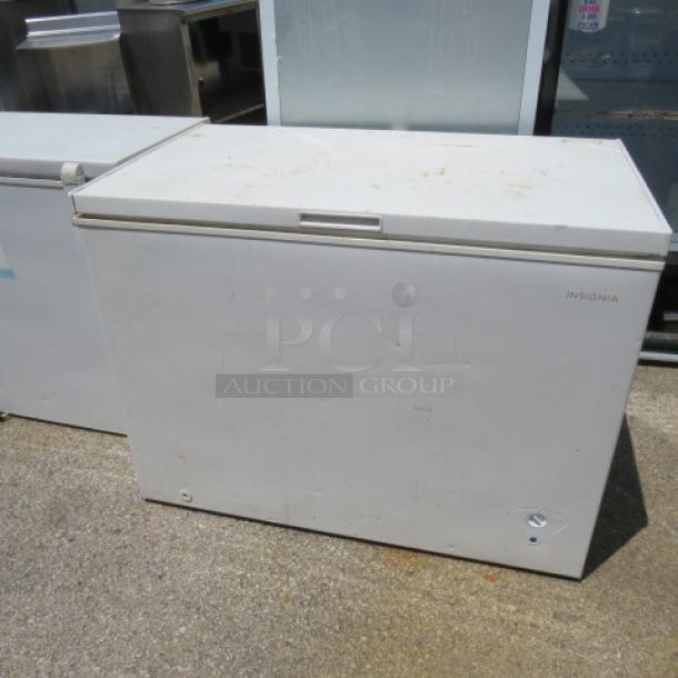 Insignia white chest freezer, scuff marks visible on surface, metal exterior, intact handle, lock mechanism. Ideal for storage.