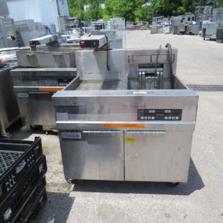 Commercial Frymaster deep fryer with dual baskets, stainless steel finish, digital controls, shown outdoors. Good condition.