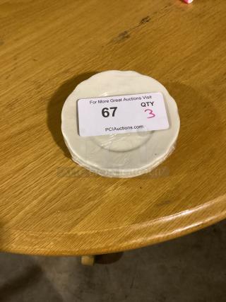 Scalloped 5-1/2 inch bread plates, set of 3, wrapped in plastic, displayed on a wooden table, label reads "67 QTY 3."