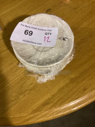 12 white dessert plates, 5-1/2 inches, wrapped in plastic. Auction tag shows lot 69, quantity 12.