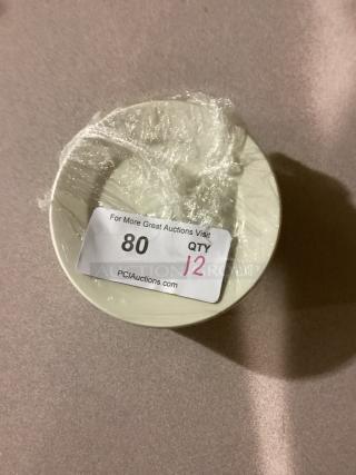 Set of 12 medium desert plates, 6-1/2 inches, wrapped in plastic. Auction label showing quantity and auction site details.
