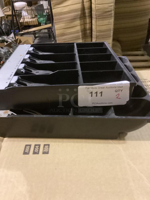 Two black cash register drawers, each with multiple compartments, in good condition. Tag reads "Qty: 2, 111."