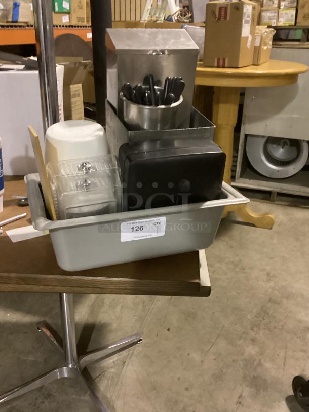 Assorted kitchen items in gray bin, includes utensils, metal holder, plastic containers. Auction label "126, QTY 1" visible.