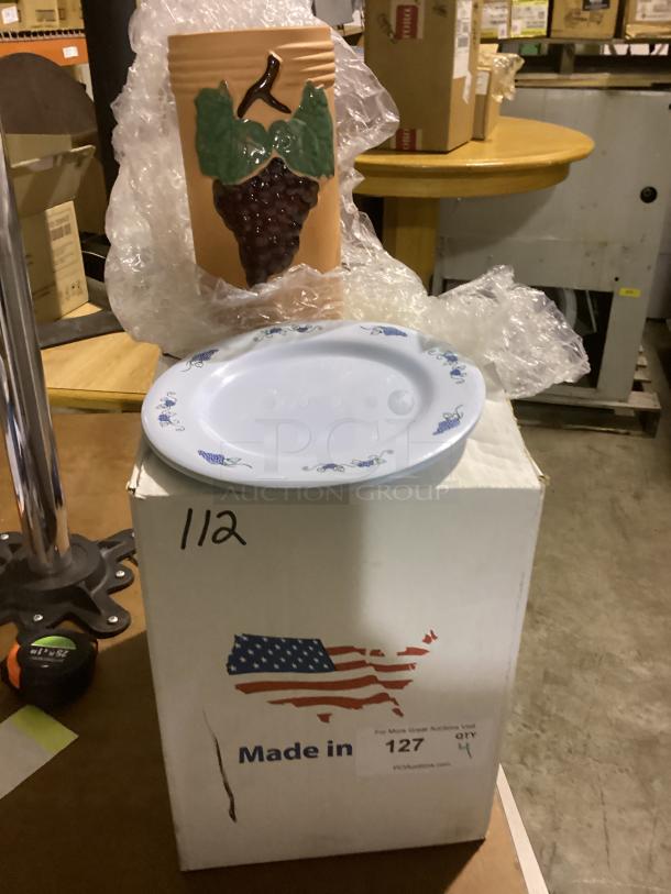 Miscellaneous kitchenware includes a ceramic vase with grape design and a round white plate with blue patterns on a box labeled "Made in USA."