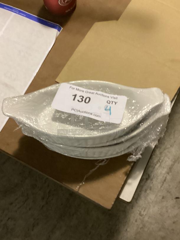 Set of four oval gravy dishes, 9-3/4 inches, wrapped for protection. Label indicates quantity of four. Item number 130.