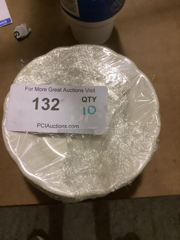 10 medium scalloped desert plates, 6-3/8 inches, wrapped, marked as lot 132, in good condition.