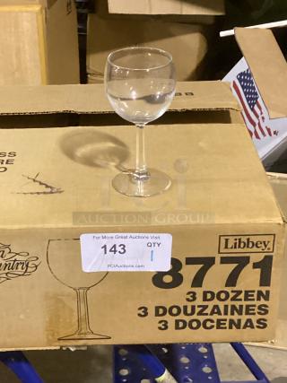 Libbey red wine glass on cardboard box, labeled "8771 3 DOZEN," auction tag "143 QTY 1."