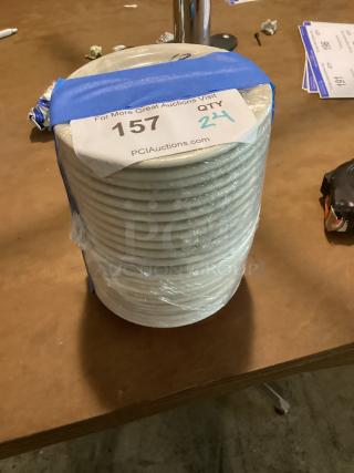 24 small desert plates, 5.5 inches, stacked with auction tag stating quantity, wrapped in clear plastic.