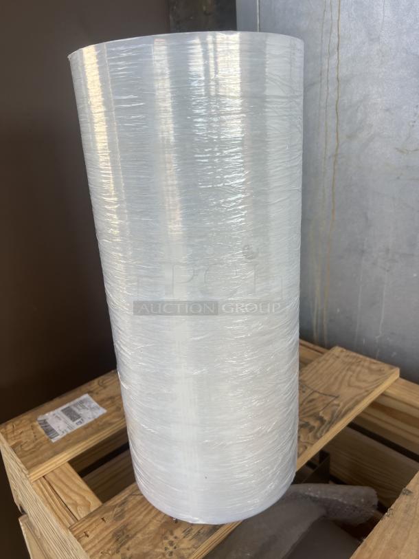 Large shrink wrap roll on wooden pallet, clear plastic, cylindrical, unused condition. Auction quantity: 10 rolls.