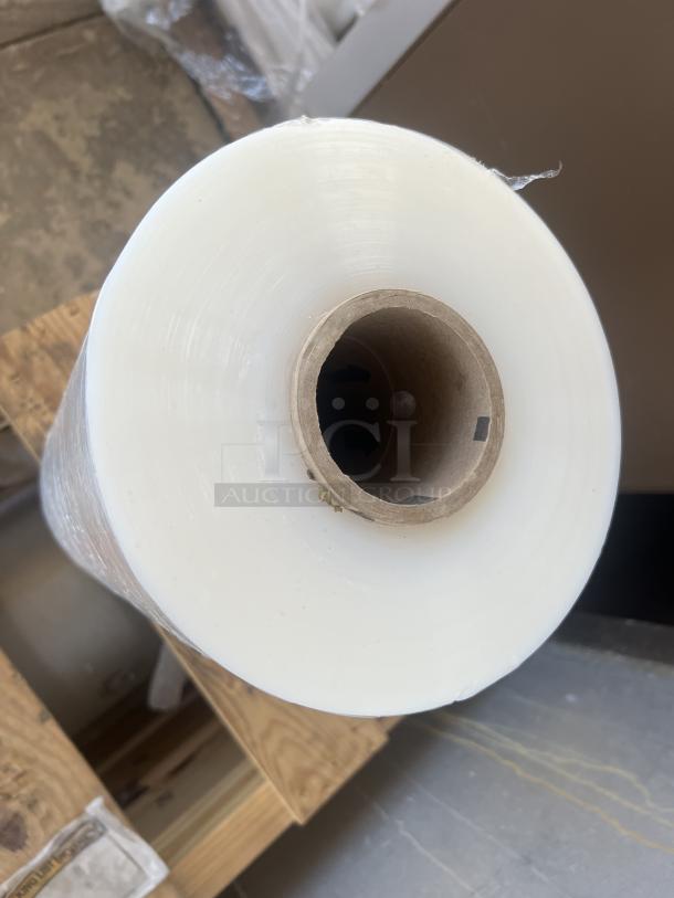 Large shrink wrap roll, white, unused, full length, core visible, quantity of 10 rolls available for bidding.