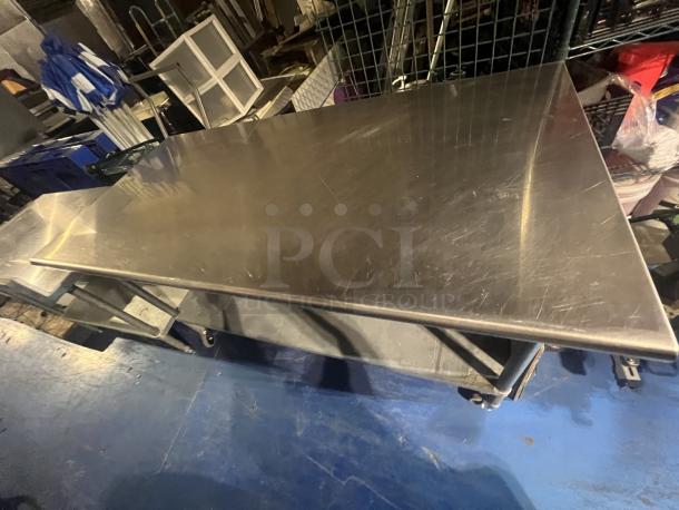 Stainless steel table, 72x30x39 inches, polished surface, minor scratches, sturdy condition, ideal for industrial use.