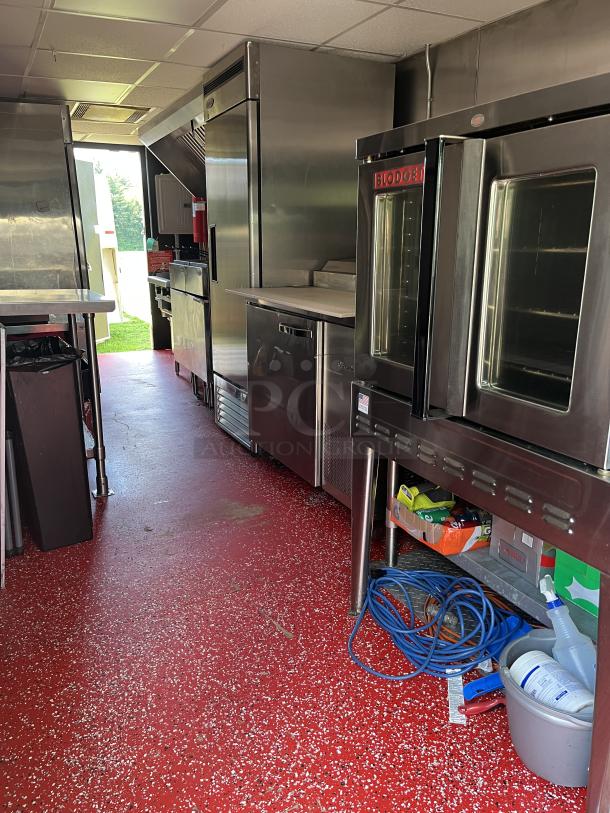 Commercial kitchen with stainless steel appliances, including a Blodgett oven. Bright red speckled floor, used condition.