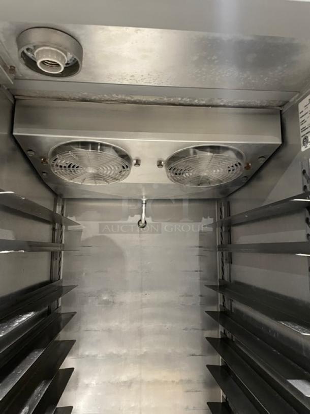 Commercial stainless steel refrigerator interior, featuring dual cooling fans and adjustable shelving. Excellent condition.