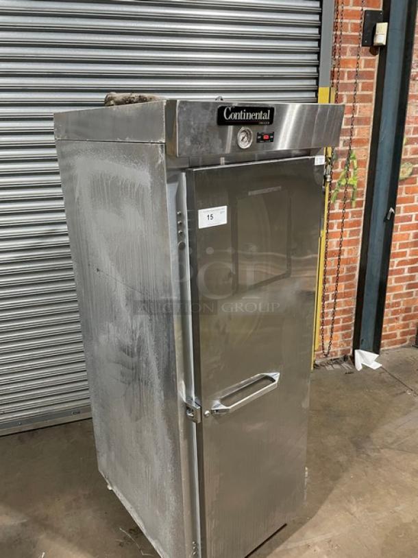 Commercial stainless steel refrigerator by Continental, single door, temperature gauge, minor wear, auction tag 15 visible.